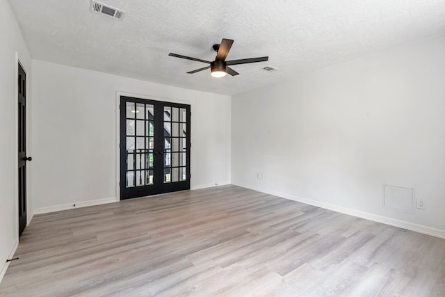 unfurnished room with ceiling fan, a textured ceiling, light hardwood / wood-style floors, and french doors