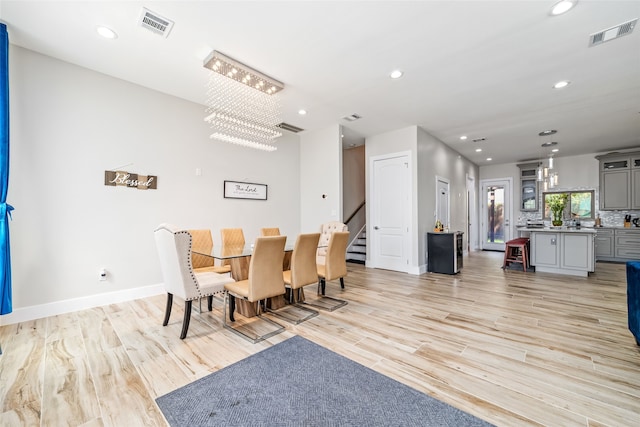 dining area featuring light hardwood / wood-style flooring and a notable chandelier