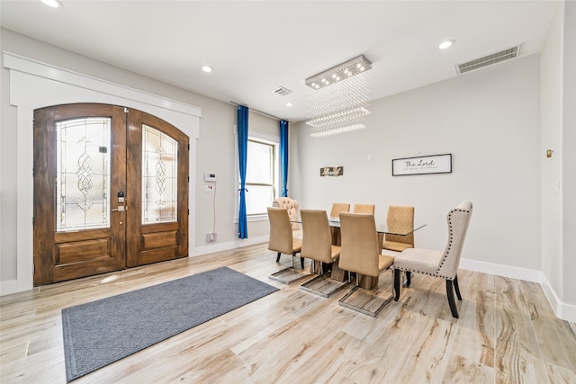 interior space featuring light hardwood / wood-style flooring, a chandelier, and french doors