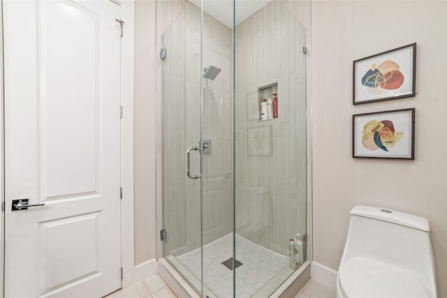 bathroom featuring tile patterned flooring, toilet, and an enclosed shower