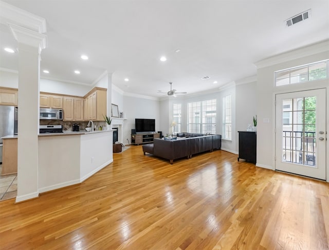 kitchen featuring crown molding, light brown cabinetry, appliances with stainless steel finishes, ceiling fan, and light hardwood / wood-style floors