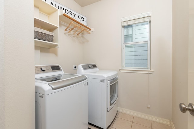 washroom featuring washing machine and clothes dryer and light tile patterned floors