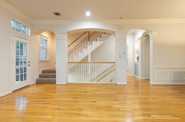 unfurnished room featuring ornate columns, light hardwood / wood-style flooring, and ornamental molding