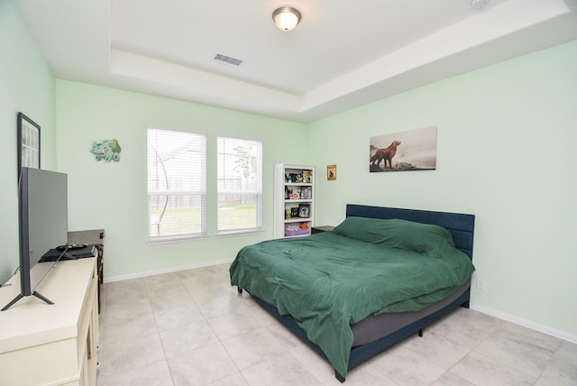 tiled bedroom with a tray ceiling