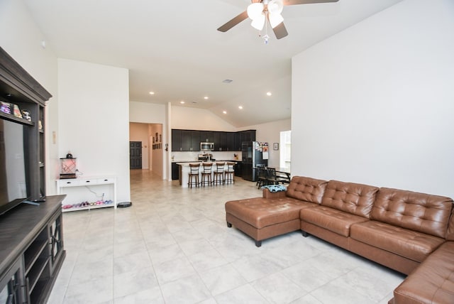 living room with ceiling fan, light tile patterned floors, and vaulted ceiling