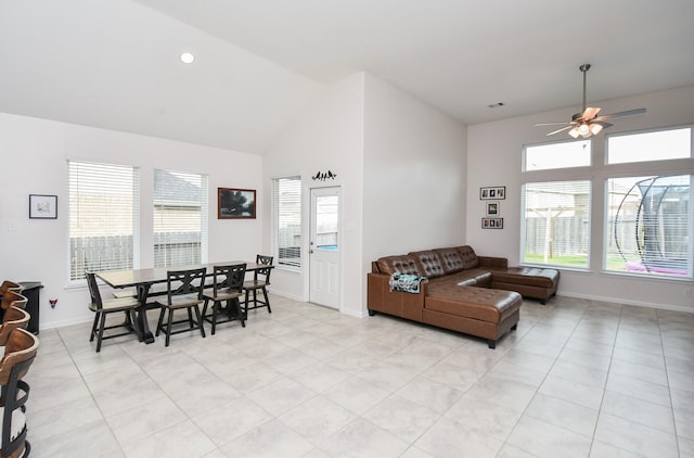 tiled living room with ceiling fan and vaulted ceiling