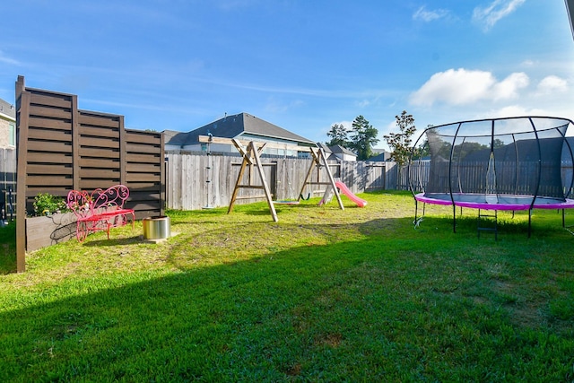 view of yard with a playground and a trampoline