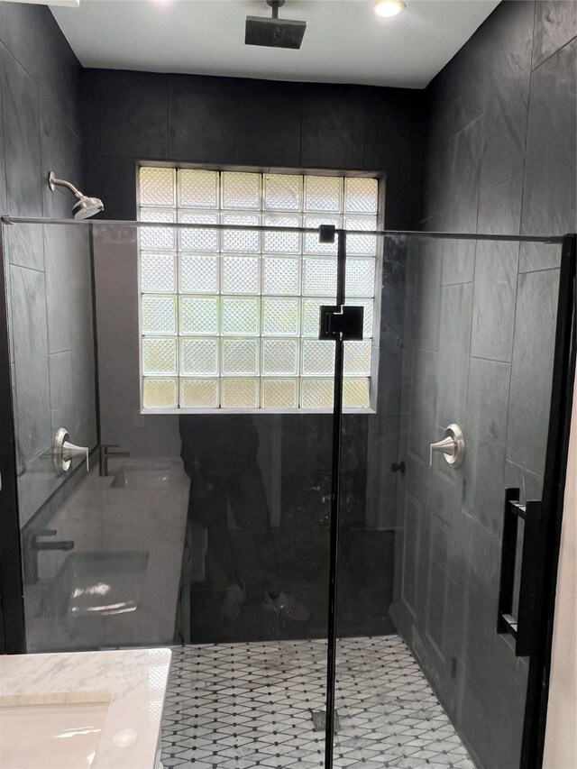 bathroom with a shower with door and sink