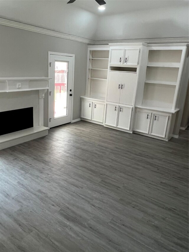 unfurnished living room featuring ornamental molding, ceiling fan, and dark wood-type flooring