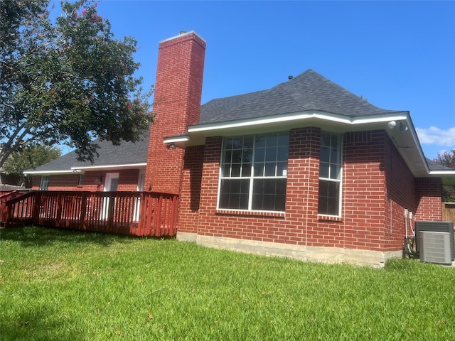 rear view of house featuring a deck, a yard, and central AC unit