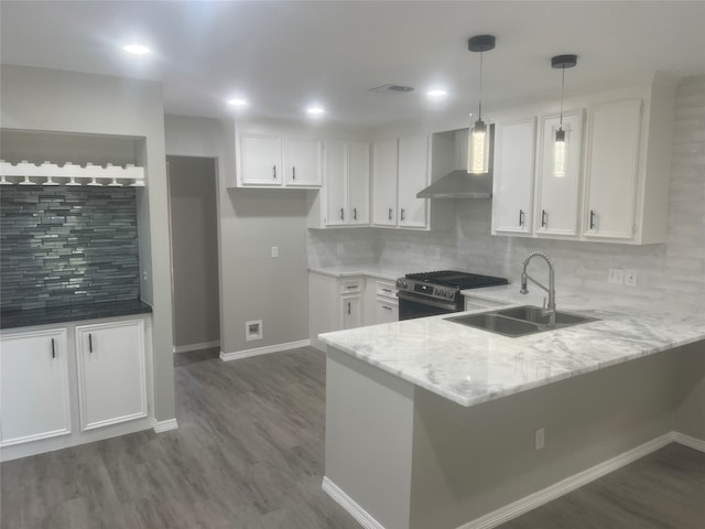 kitchen featuring white cabinetry, stainless steel gas stove, kitchen peninsula, and wall chimney range hood