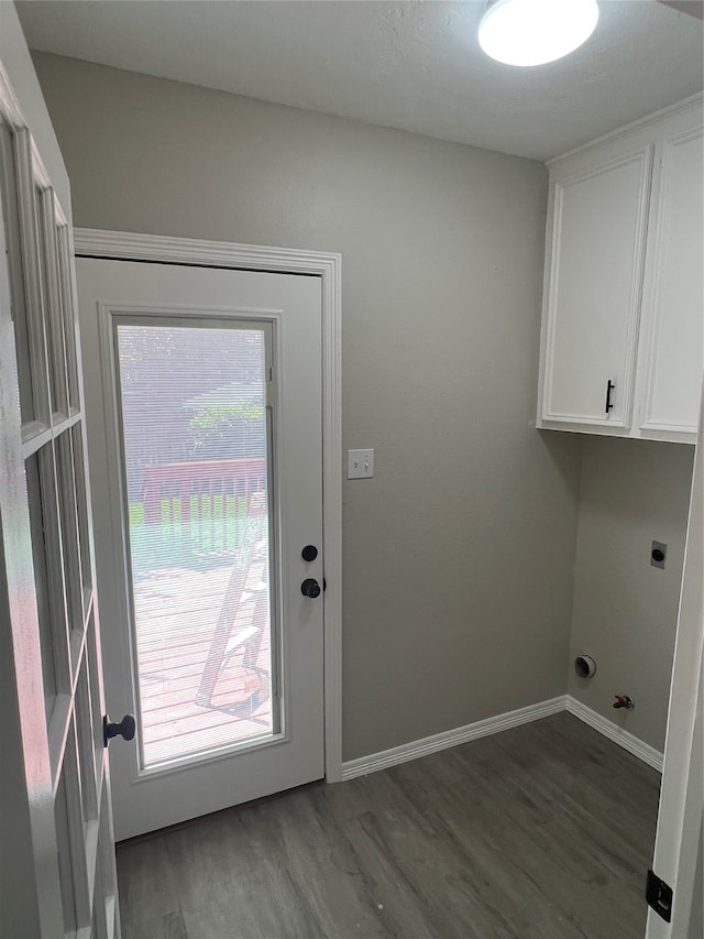 clothes washing area featuring electric dryer hookup, cabinets, wood-type flooring, and a wealth of natural light