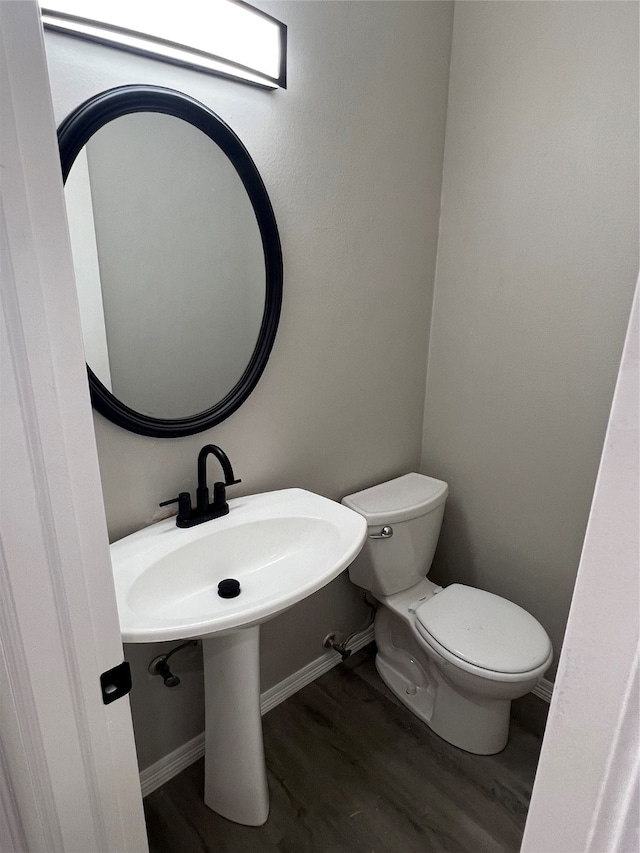 bathroom with hardwood / wood-style flooring and toilet