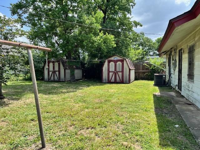 view of yard with a storage shed and central air condition unit