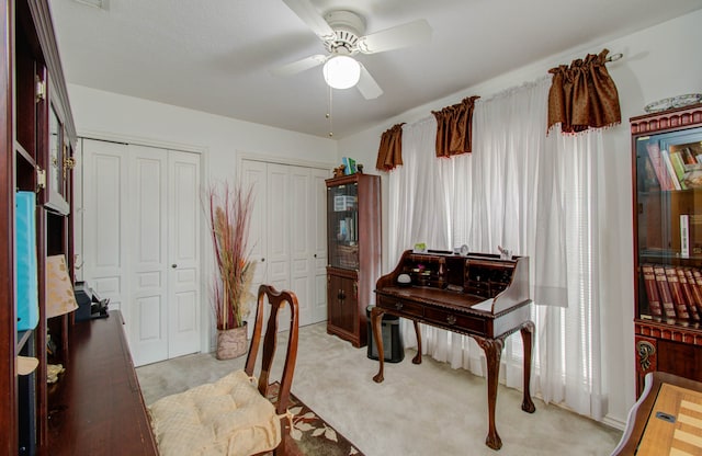 interior space with ceiling fan and light colored carpet