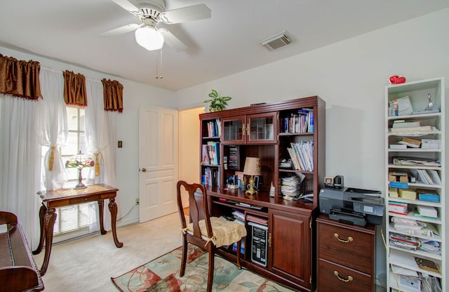 carpeted office space with ceiling fan