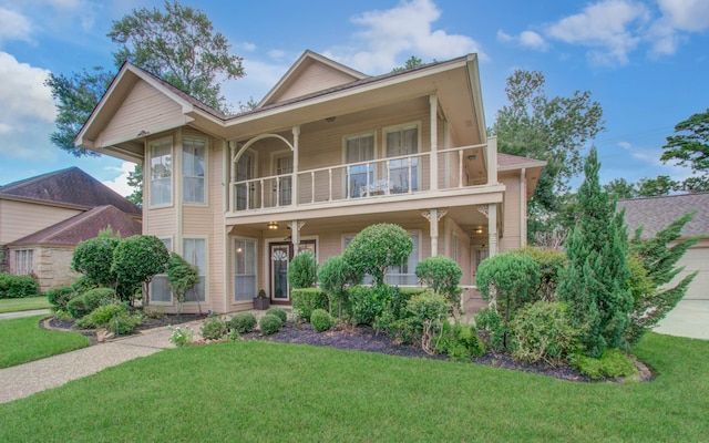 view of front of home with a balcony, a porch, and a front lawn