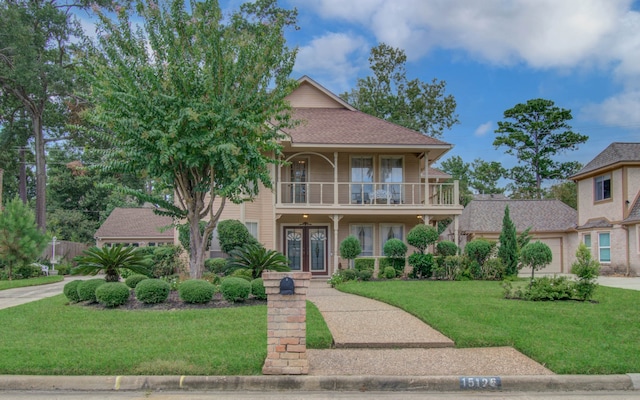 view of front of home featuring a balcony and a front lawn