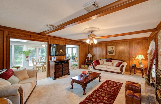 carpeted living room featuring ceiling fan, a textured ceiling, plenty of natural light, and wood walls