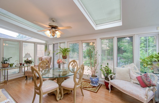 sunroom / solarium featuring a healthy amount of sunlight, lofted ceiling with skylight, and ceiling fan