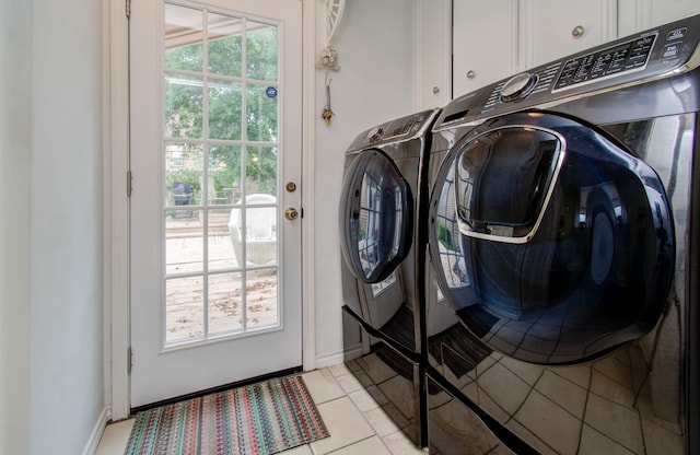 clothes washing area featuring cabinets, washing machine and clothes dryer, and light tile patterned flooring