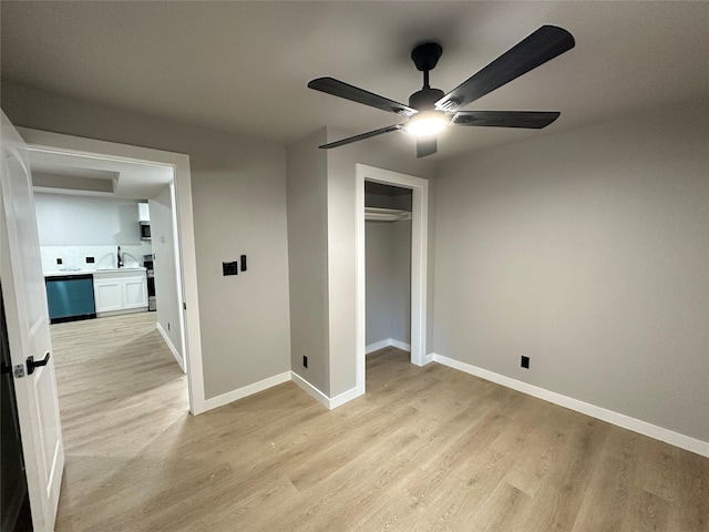 unfurnished bedroom with ceiling fan, light hardwood / wood-style floors, sink, and a closet