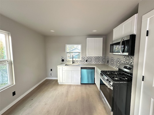 kitchen with white cabinetry, sink, stainless steel appliances, light hardwood / wood-style flooring, and decorative backsplash