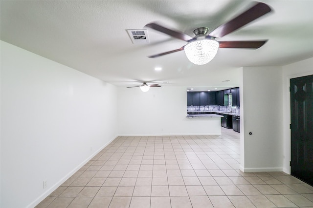 spare room featuring sink, ceiling fan, and light tile patterned flooring