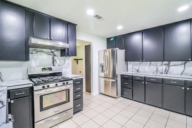 kitchen featuring stainless steel appliances, light tile patterned floors, and backsplash