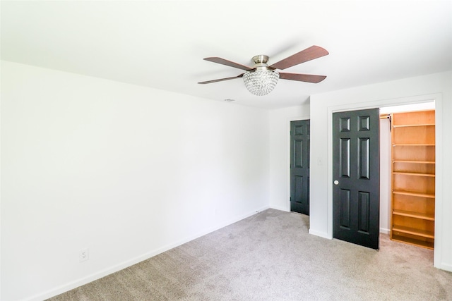 unfurnished bedroom featuring ceiling fan, a closet, and light carpet