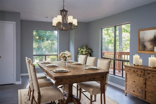 dining space featuring dark wood-type flooring, an inviting chandelier, and plenty of natural light