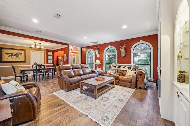 living area featuring visible vents, crown molding, and wood finished floors