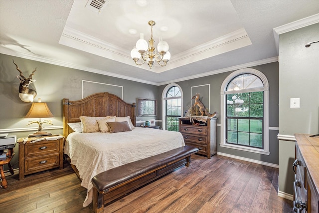 bedroom with crown molding, a notable chandelier, a tray ceiling, and dark hardwood / wood-style flooring