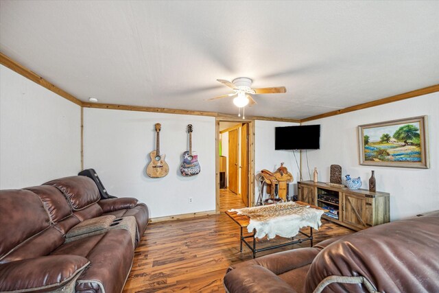 living room featuring wood-type flooring, ceiling fan, and ornamental molding