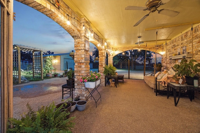 patio terrace at dusk featuring ceiling fan