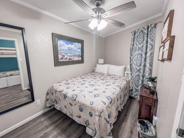 bedroom with a textured ceiling, ceiling fan, crown molding, and dark wood-type flooring