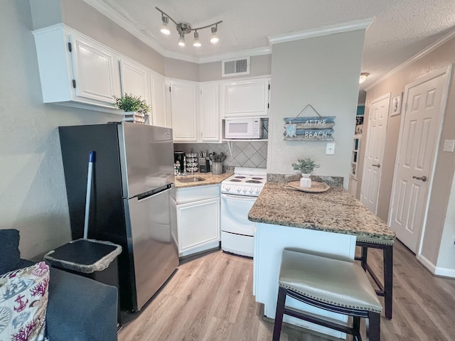 kitchen with a kitchen bar, white appliances, light stone countertops, light hardwood / wood-style floors, and white cabinets