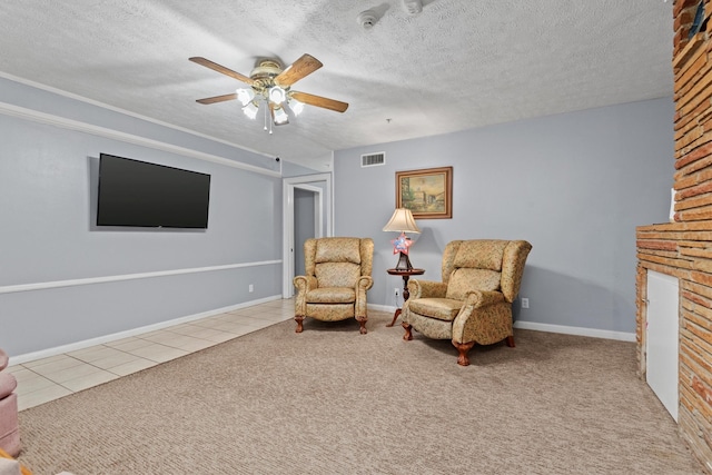 sitting room featuring ceiling fan, light carpet, and a textured ceiling