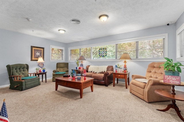 living room featuring a wealth of natural light, light colored carpet, and a textured ceiling