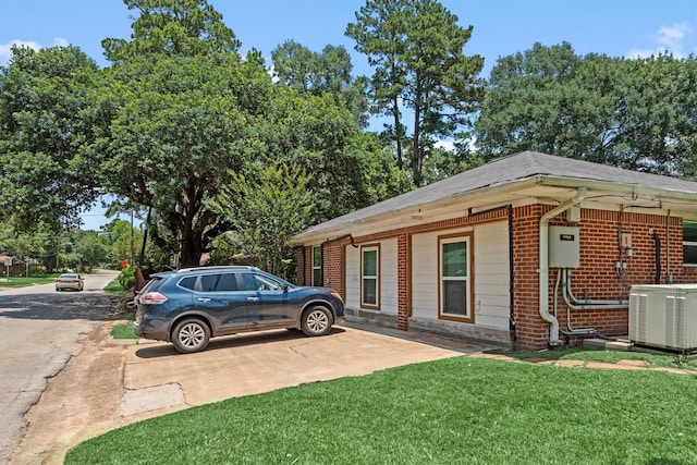 view of property exterior with a yard and central air condition unit