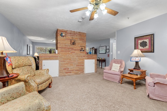 living room featuring ceiling fan, carpet flooring, and a textured ceiling