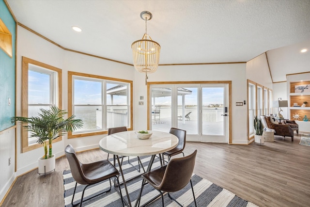 dining space with crown molding, an inviting chandelier, and dark hardwood / wood-style flooring