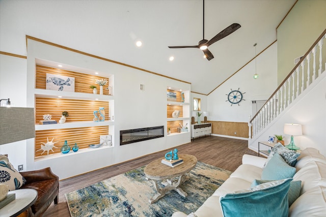 living room with ceiling fan, hardwood / wood-style flooring, high vaulted ceiling, ornamental molding, and wooden walls