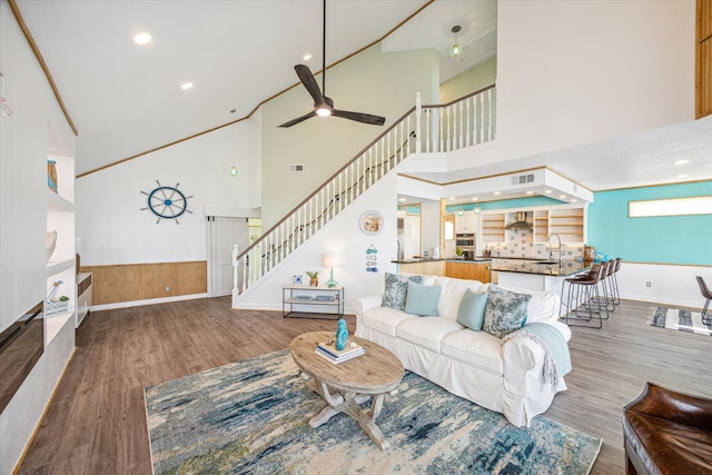 living room featuring ceiling fan, high vaulted ceiling, wood-type flooring, and sink