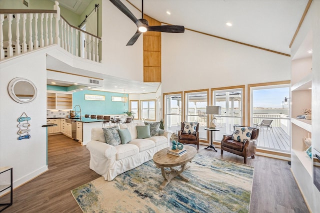 living room with hardwood / wood-style flooring, high vaulted ceiling, and ceiling fan