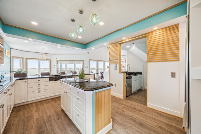 kitchen featuring stainless steel dishwasher, a center island, light hardwood / wood-style flooring, and white cabinets