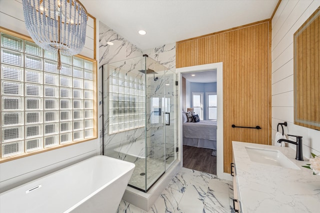 bathroom with vanity, separate shower and tub, and an inviting chandelier