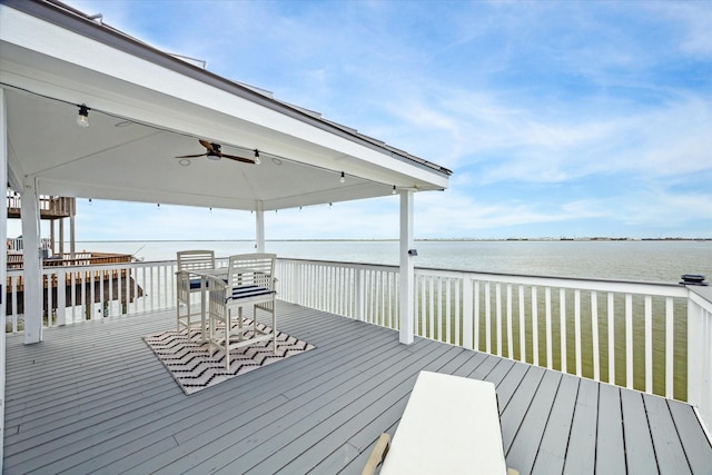 wooden terrace featuring ceiling fan and a water view