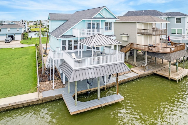 exterior space with a deck with water view, a balcony, and a yard