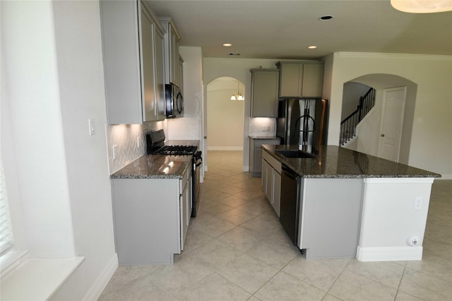 kitchen featuring tasteful backsplash, sink, dark stone countertops, and black appliances